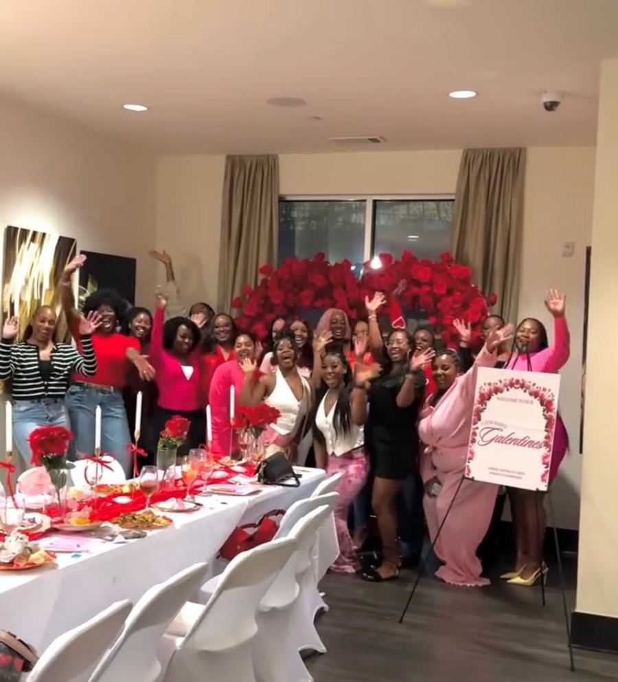 The women at Galentines in front of a heart of red roses